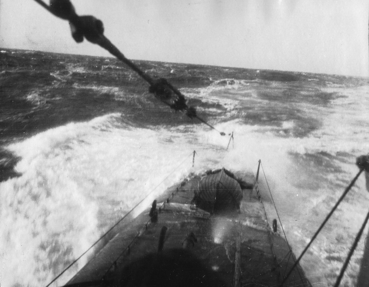 Ubåten "Valrossen" går upp över ytan. Fören bryter vattnet och vågorna bildas.