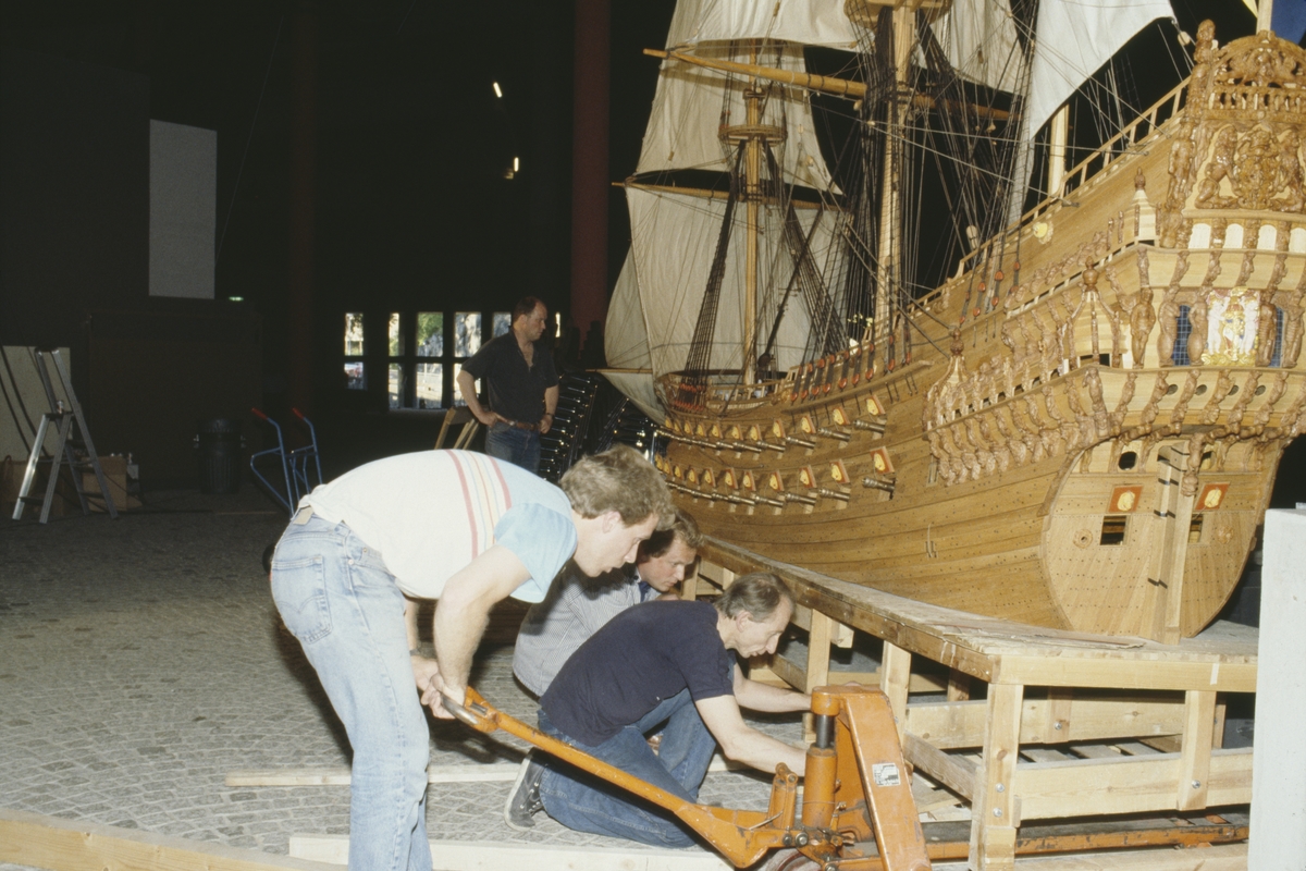 Modellen av Vasa i skala 1:10 justeras på plats i Vasamuseet. Fr.v. Stefan Bruhn, Göran Forss, Lars Thorhagen och i bakgrunden Carl-Gunnar Olsson.