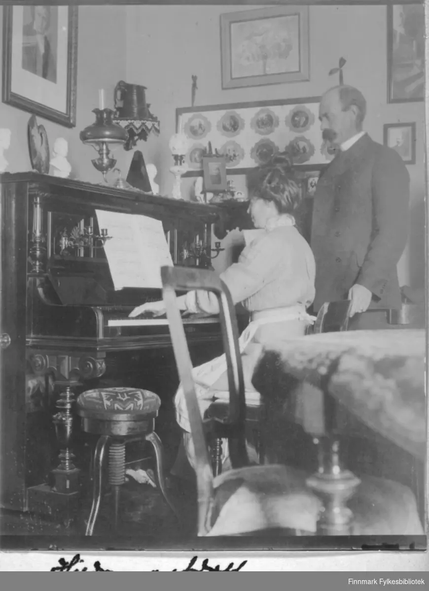 Kvinne som spiller piano, mann som tilhører. 'Hildur [?] og Adolf'