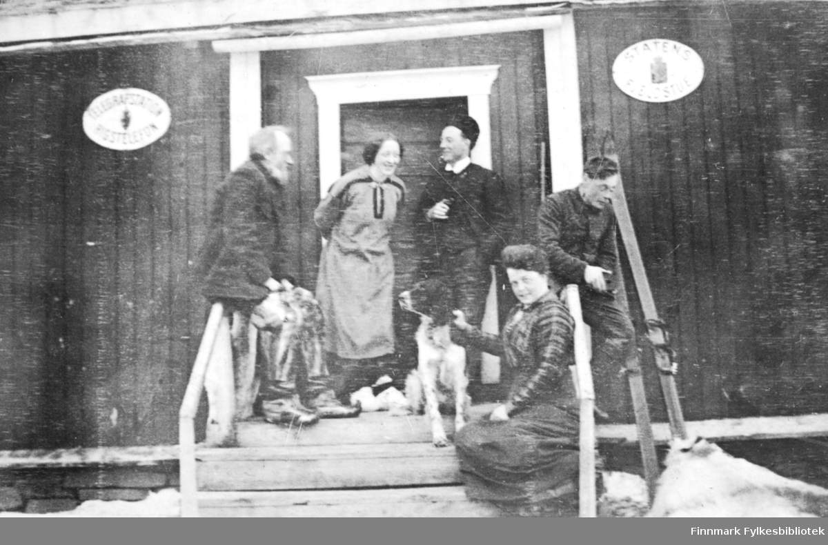 På trappa til Levajok fjellstue i april 1916. Fem personer og en hund er avbildet. Kvinnen med hund er Signe Solem. På veggen henger det to skilt. skiltet til venstre har teksten 'TELEGRAFSTATIONEN RIGSTELEFON' og på det til høyre står det 'STATENS FJELDSTUE' Ved siden av trappen står det et par ski.