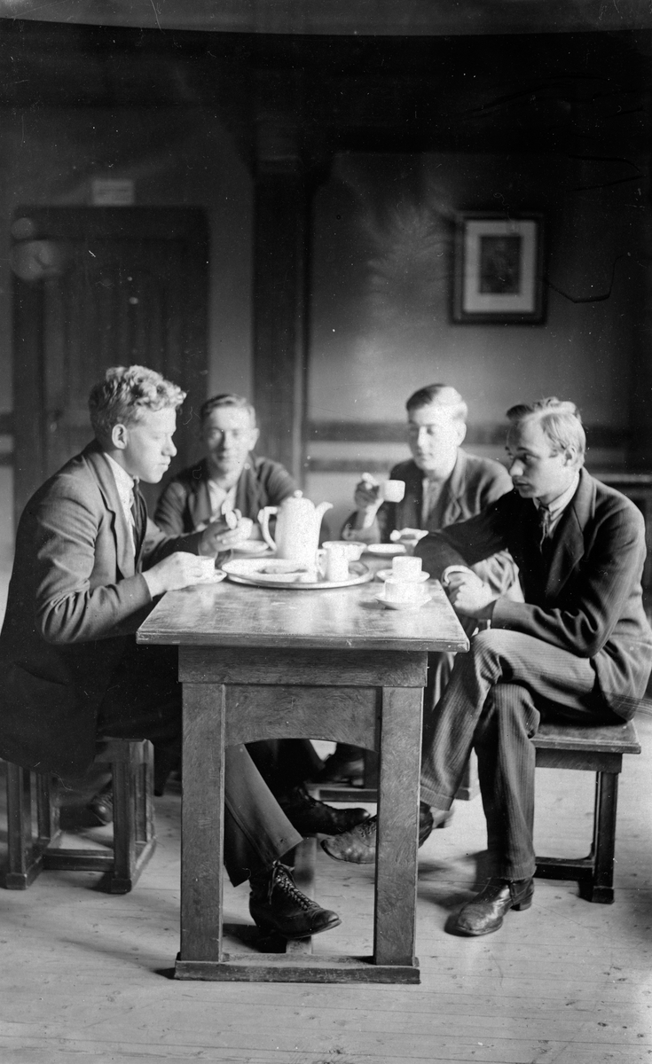 Gustav Andersson (till höger) med tre kamrater vid ett kaffebord.