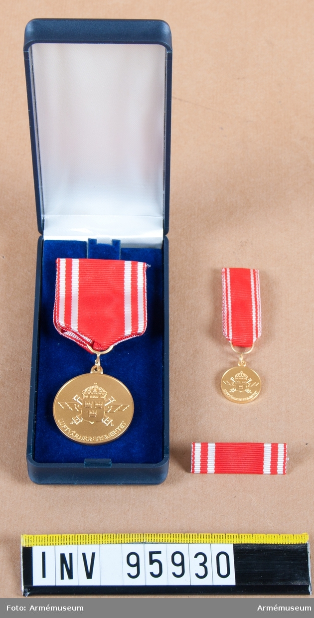 Luftvärnsregementets (Lv 6) förtjänstmedalj i guld, 8:e storleken, 2001. 

Band: rött med två vita ränder på vardera sidan.

Medalj, miniatyrmedalj, släpspänne och band i blå ask klädd med blå sammet och vit siden.