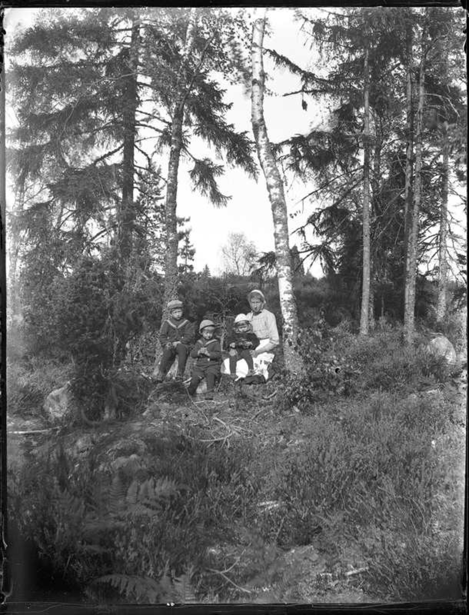 Sven, Hjärtum 1915-05-14, Nils, Hjärtum 1918-01-09, Erik, Hjärtum 1919-07-26, Olga, född Olsson, Forshälla 1891-05-12, i skogen.