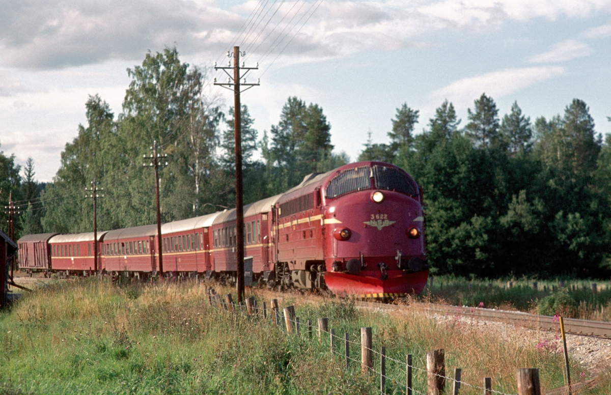 Rørosbanens dagtog Ht 302 Trondheim - Oslo Ø kjører ut fra Koppang stasjon med dieselelektrisk lokomotiv Di 3 622 og vogner type 3.