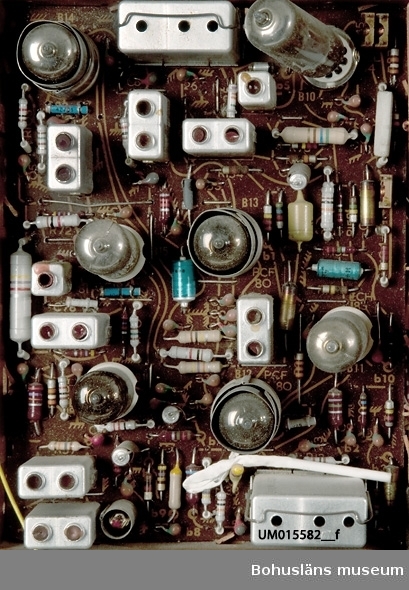 21-tums TV inbyggd i teakskåp med skjutdörrar dvs. dubbla jalusiedörrar som dras för rutan från sidorna när apparaten inte används.
Sladd med stickkontakt avklippt.
Apparaten var utställd i gamla basutställningen, 1960-talet.