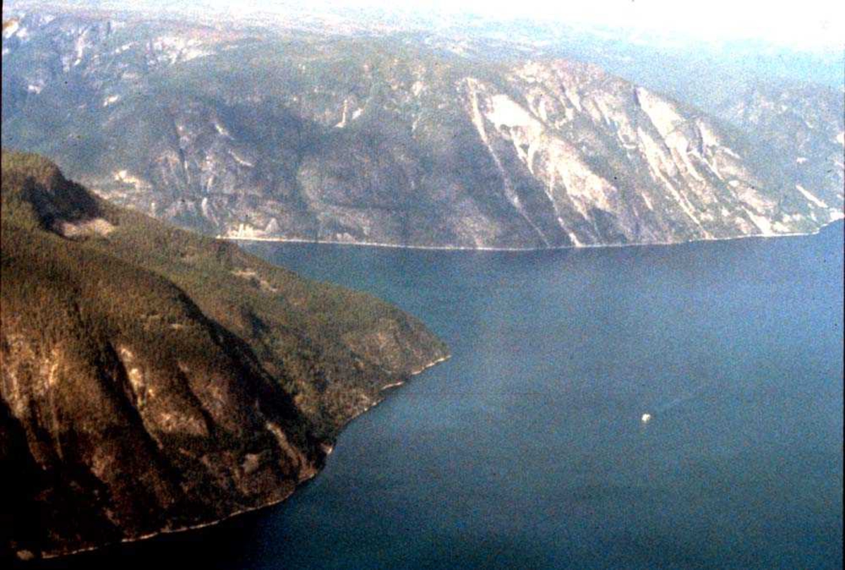 Luftfoto. Fjell og blankstille fjord ett sted på Vestlandet.