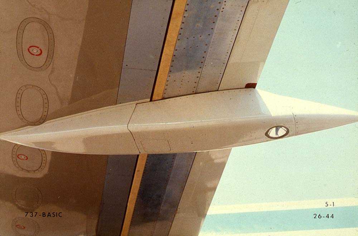 Detaljbilde av undersiden av vingen på ett fly med et lys, Boeing 737-200.