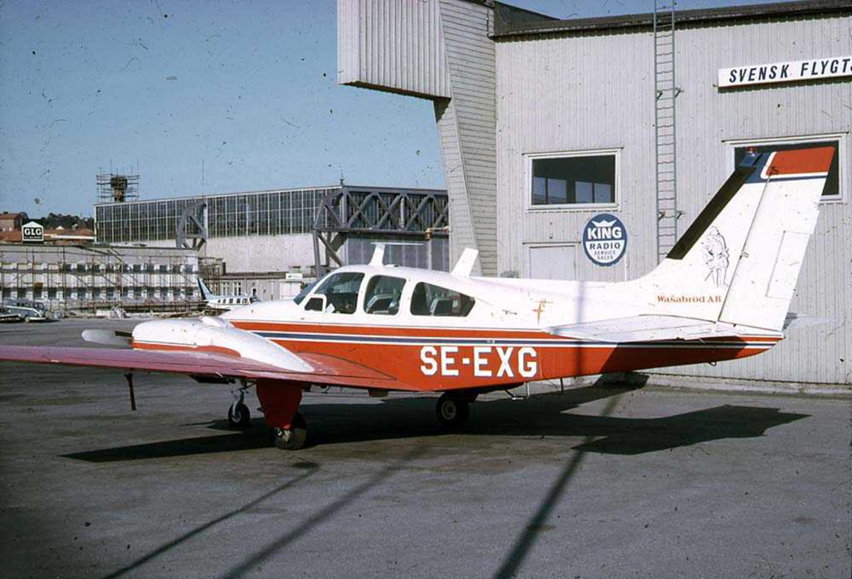 Lufthavn. Ett fly på bakken, Beechcraft 95-B55/C55 Baron SE-EXG. Bygninger i bakgrunnen.