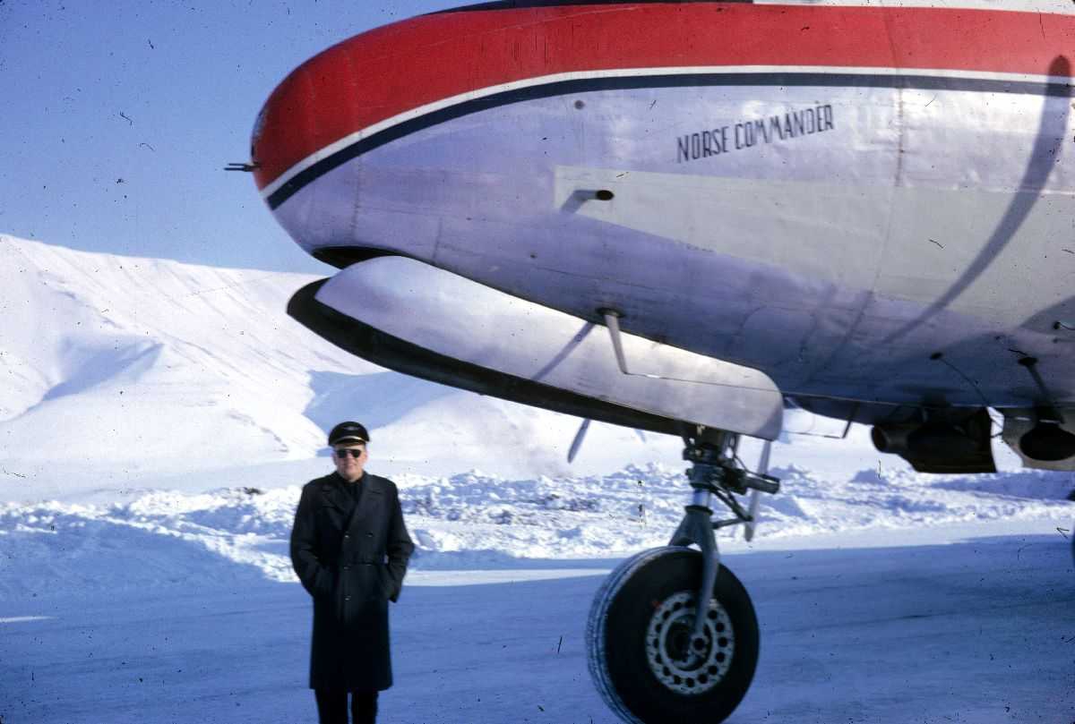 Lufthavn. En person som står ved ett fly på bakken, Douglas DC-4 "Norse Commander" LN-SUP fra Braathens SAFE. Snø på bakken.