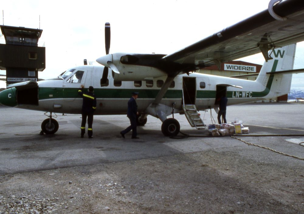 Lufthavn (flyplass). Et fly, LN-WFC, DHC-6-300 Twin Otter fra Widerøe parkert. Flere personer ved flyet.