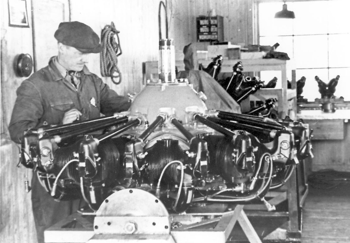 Interiør, inne i verksted. en person, ettersyn på  flymotor for propelldrift. Motoren tilhører Junkers Ju 52/3mg3e. 