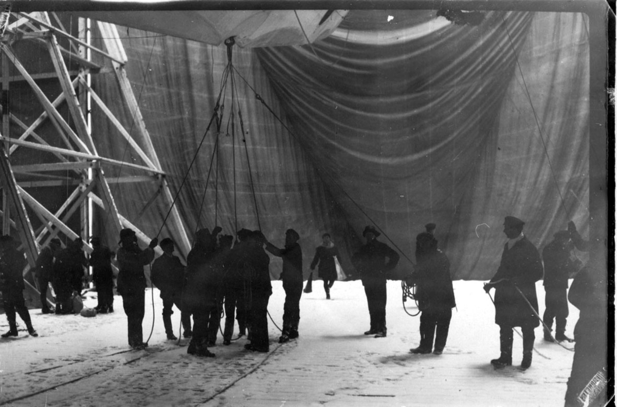 Litt av luftskipet "Norge" inne i hangaren, Flere personer i arbeid.
