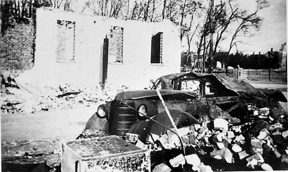 Ruin av bygning. Bodø etter bombingen under 2. verdenskrig. Bilvrak i forgrunnen, Studebaker 1938 med reg.nr. W-26