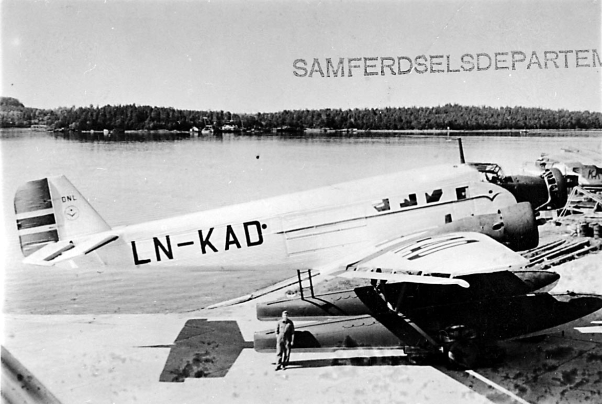 Sjøflyhavn, 1 sjøfly står på land, Junkers JU 52 3mg g8e, LN-KAD "Per" fra DNL A/S Oslo. 1 person foran flyet.