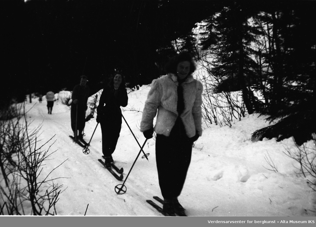 Skiløype gjennom skogen med skigåere i sporet.