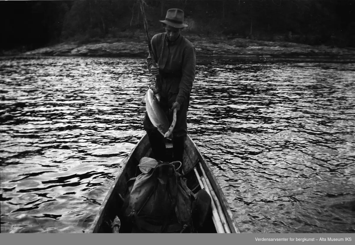 Roar står i båten med en laks.
Bildet er tatt i fiskesesongen på sommeren i 1949.