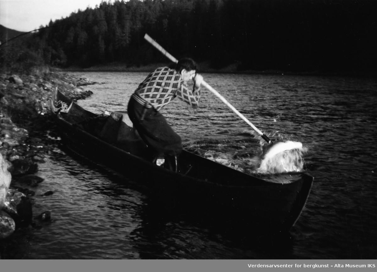 En av Tangen-brødrene tar en laks med en klepp.
Bildet er tatt i fiskesesongen på sommeren i 1949.