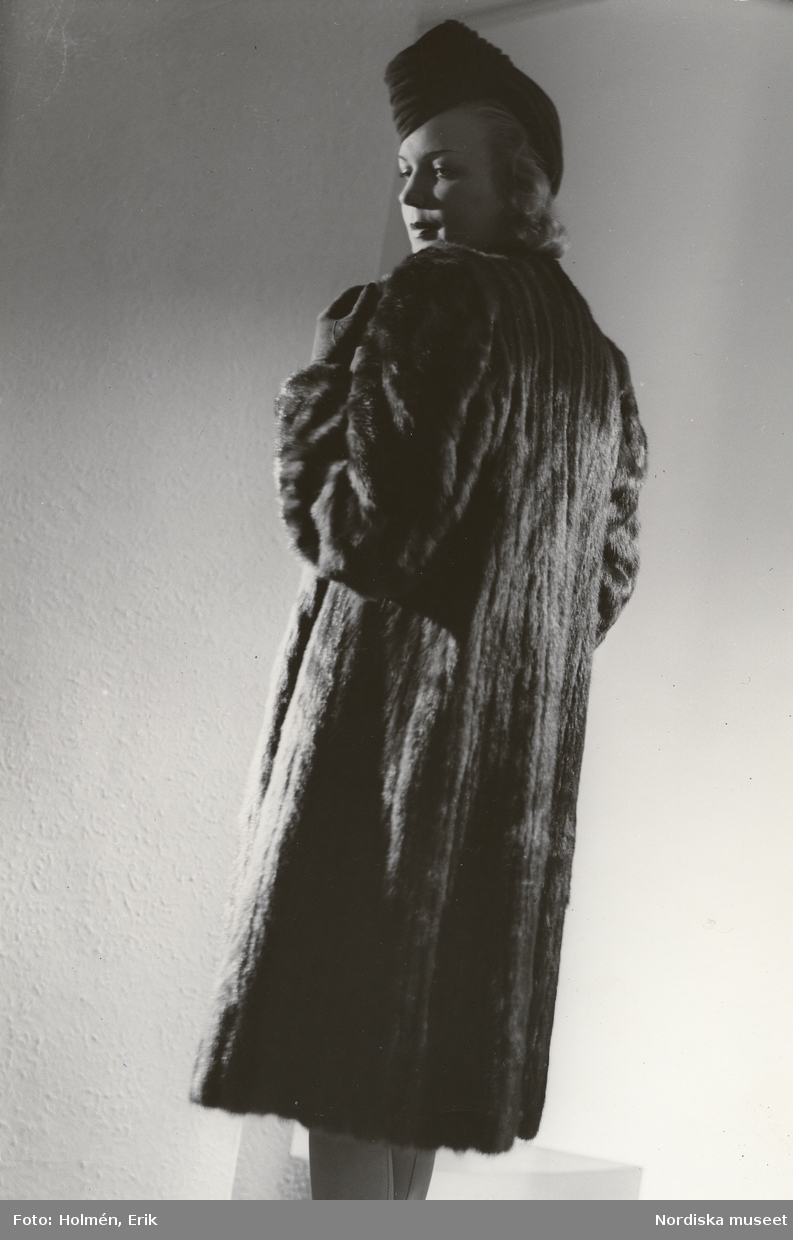 Nordiska Kompaniet. Kvinna i mörk minkpäls och mörk hatt. Text på baksidan: "Pälsar 1942 (fru Margit Langlet)"