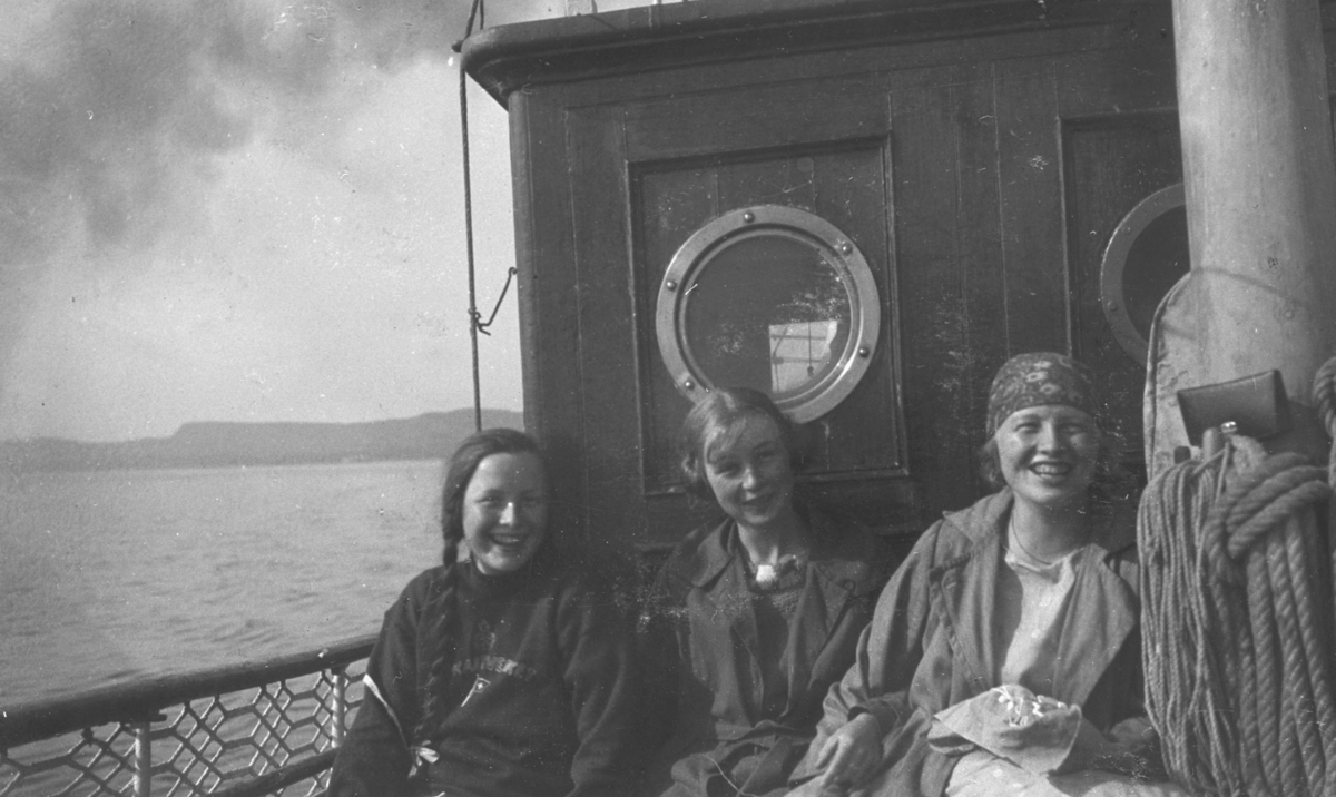 Tre unge jenter, Biddi Hermansen, Eva og Ingrid Hermansen, fotografert om om bord på oppmålingsfartøy "Wilhelm Huth". På albumet står det "De glade Huth-dager i 1925". Bilder er ikke helt identisk med bildet nr. FBib.95053-011.