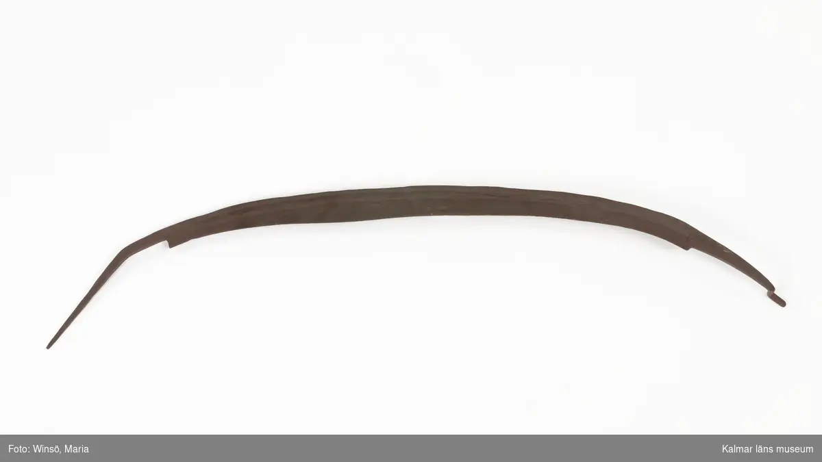 KLM 16931. Hackelsekniv, metall. Handsmitt blad av järn med två handtag, varav det ena böjt och spetsigt och det andra format som en krok. Har ursprungligen haft handtag av trä. Dessa saknas. Målat i rödbrun färg, för rostskydd, under senare tid.