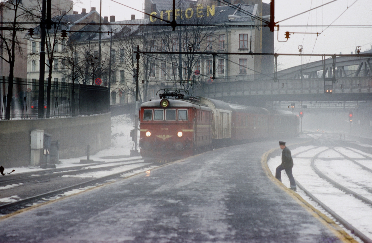Persontog med NSB elektrisk lokomotiv El 11 2110 ankommer Oslo V en tåkete desemberdag.