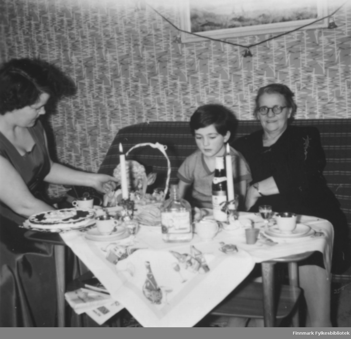 Julekaffe hos familien Ebeltoft, ca. 1953. Fra venstre: Ragnhild og Torill Ebeltoft, Svanhild Kvam. På bordet nisseduk og stearinglys