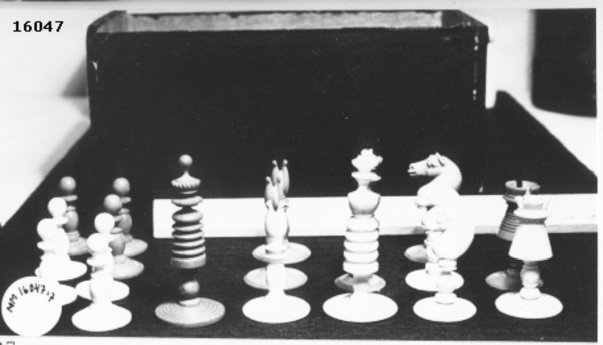 Utskuren schackpjäs,rött torn, som står på cirkelrund fot.