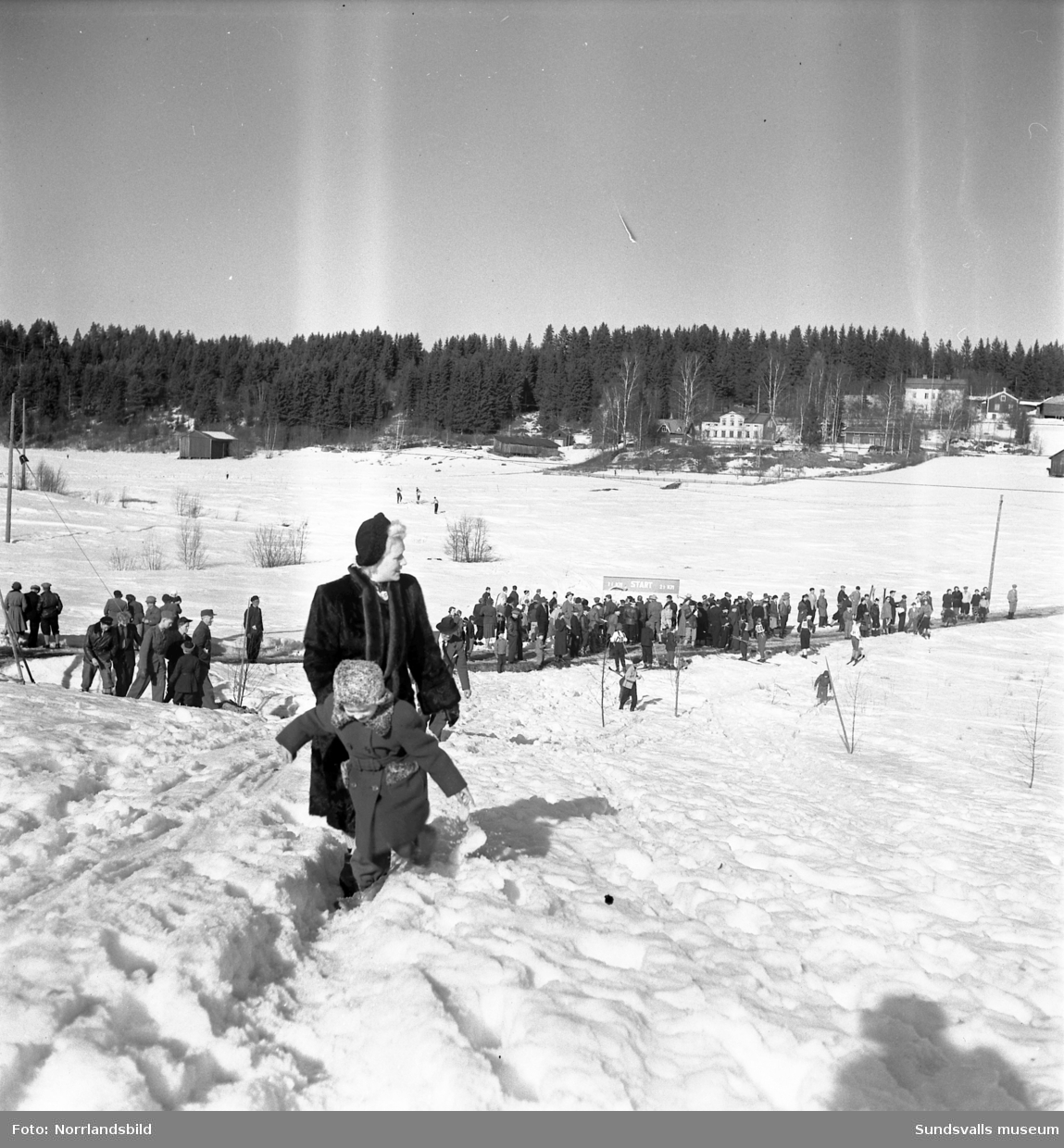 En stor bildserie från Ungdomens vinterspel i Sundsvall 1953. Längdskidor, backhoppning (i Vidarbackarna vid LV5), utförsåkning samt prisutdelning. På bild 7 ses backhopparen Sven Selånger instruera pojkar i hoppteknik.