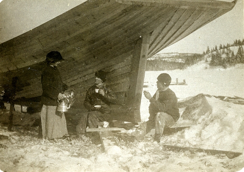 Hulda Pettersson är med kaffe hos sin bror Andreas och hans arbetskamrat Viktor Målarin när de bygger sandskutan Ella omkring 1914. Fotot gåva av E.V. Pettersson, Lungön 1952.