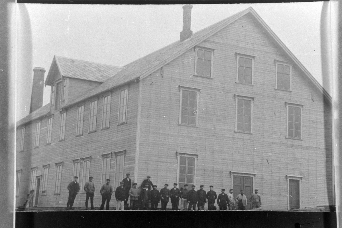 En av hermetikkfabrikkene i byen, fotografert med arbeidere i forgrunnen.