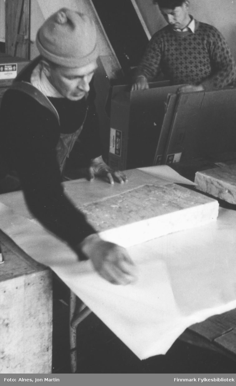 Arbeid på 'frysa' på filetfabrikken i Øksfjord, 1953. Egil Krudtå pakker fiskefileter. Jon Berntzen i bakgrunnen