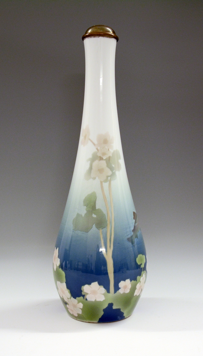 Vase av porselen, slank, glatt med lang hals. Underglasurdekor.
Modell 1512.
Dekornr. 70 Ørret og vannplante tegnet av Thorolf Holmboe.
Gjort om til lampefot.