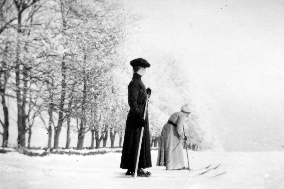 Grefsheim gård, Nes Hedmark. Vinter, kvinner på ski, skitur ved alleen
Fra venstre er fru Mellbye og Gertrud Nilson.