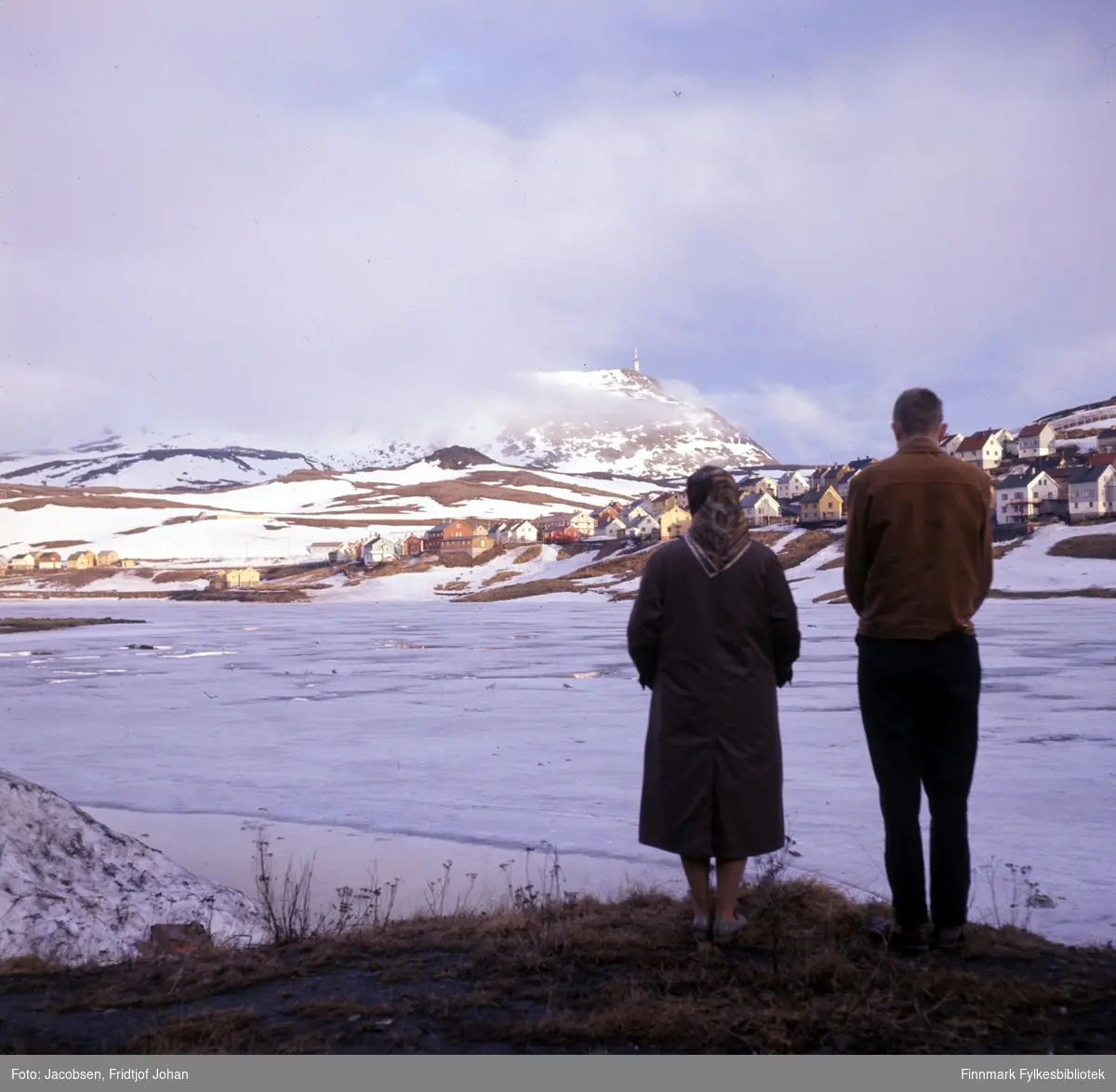 Aase og Arne Jacobsen står ved bredden av det islagte Storvannet. Fjellet Tyven med TV-masta ses såvidt mellom skyene.