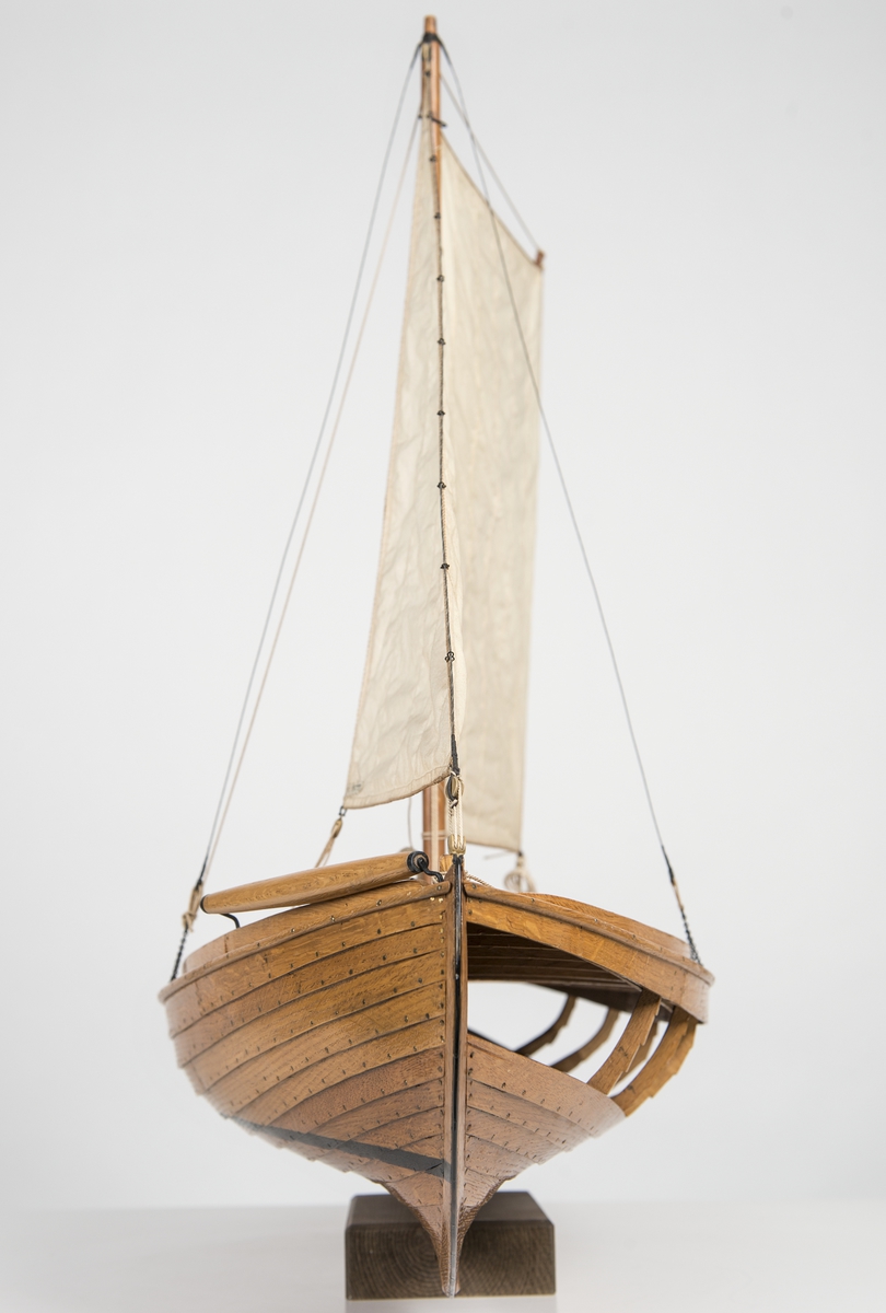 Modell av den för Öresund typiska sillfiskebåten Öresundskostern. Byggd på klink av ek, riggad, däckad fiskebåt. På styrbords bog rulle för dragningen av sillgarn. Akterut rund kapp med nedgångslucka till maskinrum. Reducerad rigg med låg mast, stagfock och sprisegel. Fartyget konstruerades av båtbyggaren A. R. Gustafsson i Landskrona, som även byggde modellen. Den korta kölen, fylliga övervattenskroppen och S-formade akterstäven är karaktäristiska drag för den senarste årtiondenas fiskefartyg. Babords sida öppen, rullbom på styrbords bog. Rund lastlucka och ruff över motorrummet. Kort mast i koger, med sprisegel och fock. Fyra lösa durkar, motor och propeller saknas. Skala 1:12.
Skrå saknas.