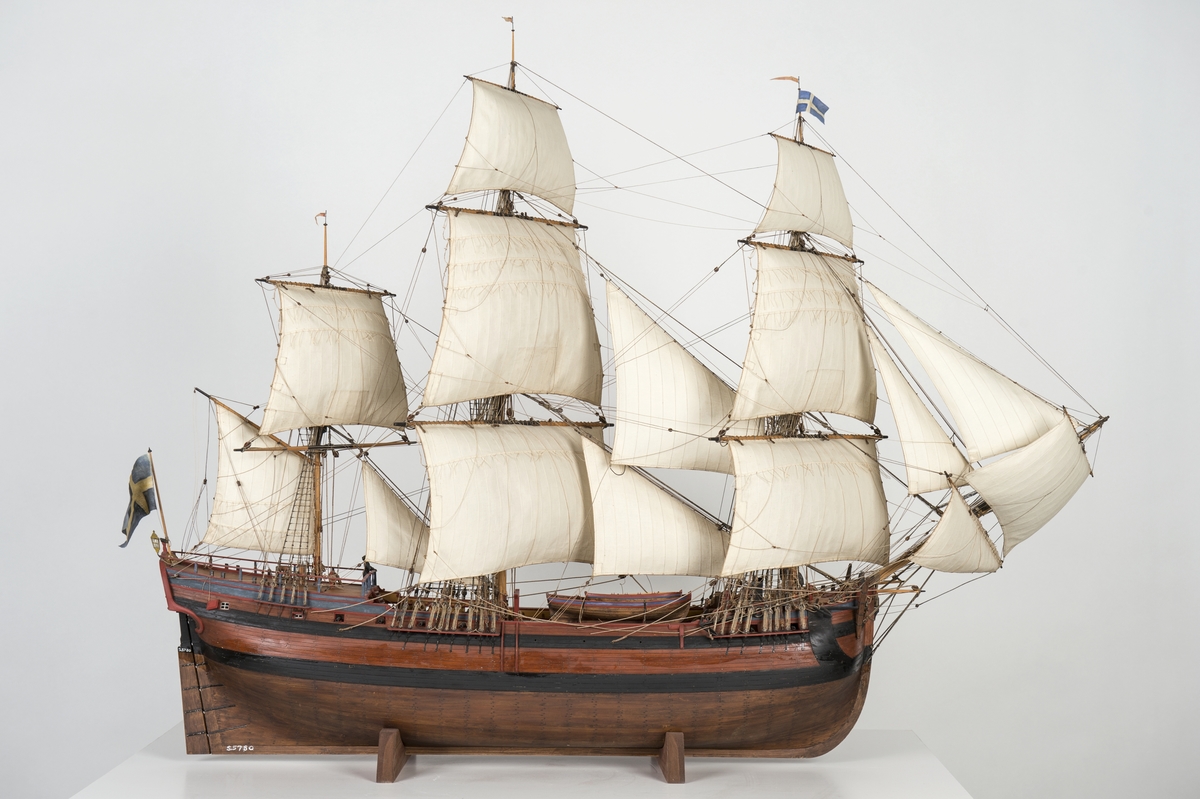 Modell av kattskeppet BARON ANDERS von HÖPKEN efter ritningar av Fredrik Henrik af Chapman daterade 1758. 6 sjömansfigurer (av bly) på däck. Monterad på sjöplatta av skulpterat trä.