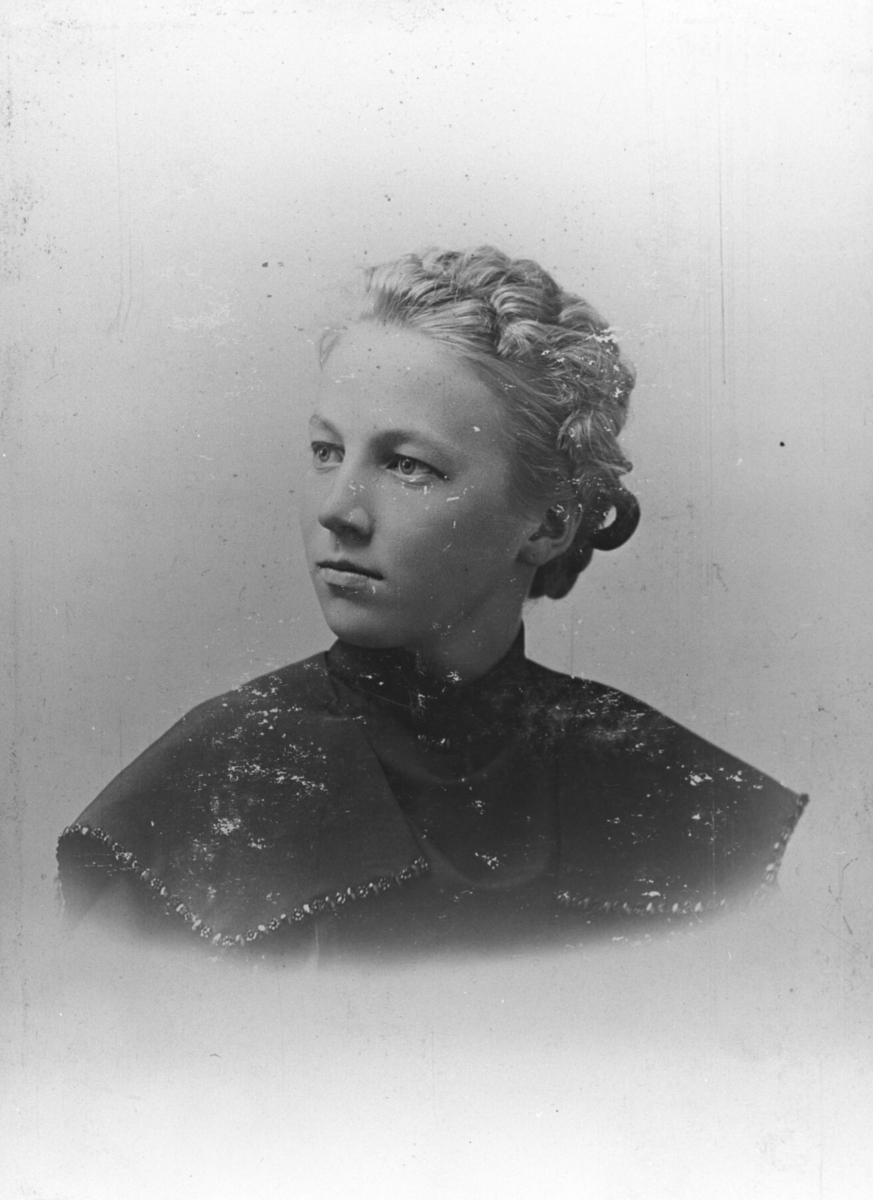 Denne unge damen er sannsynligvis Kathinka Franciska Olsen (født 1885 i Vadsø). Hun ble kalt for "Kate". Emigrerte til Calumet i Michigan. Kate døde i Detroit i 1968.
