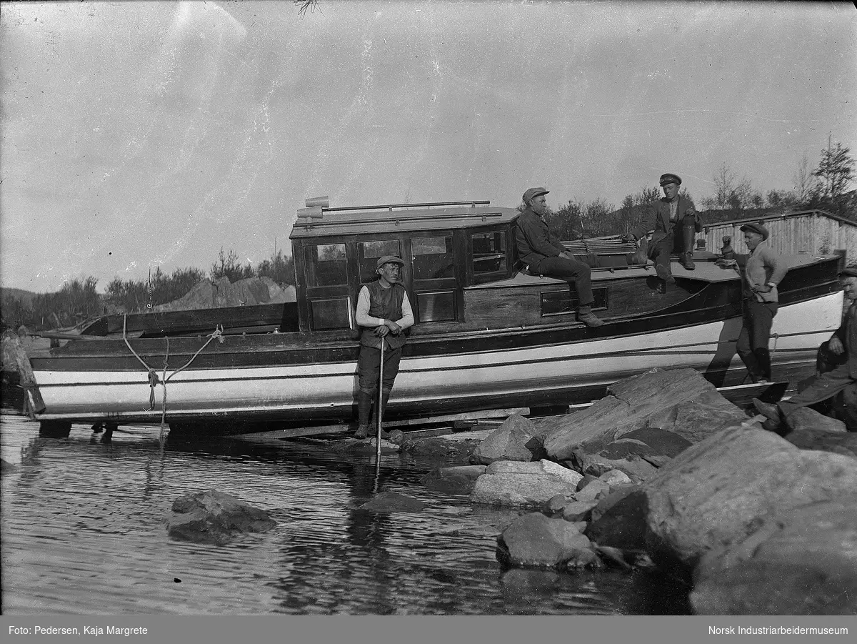 Eyde-båten med styrhus. To menn stående foran båten.