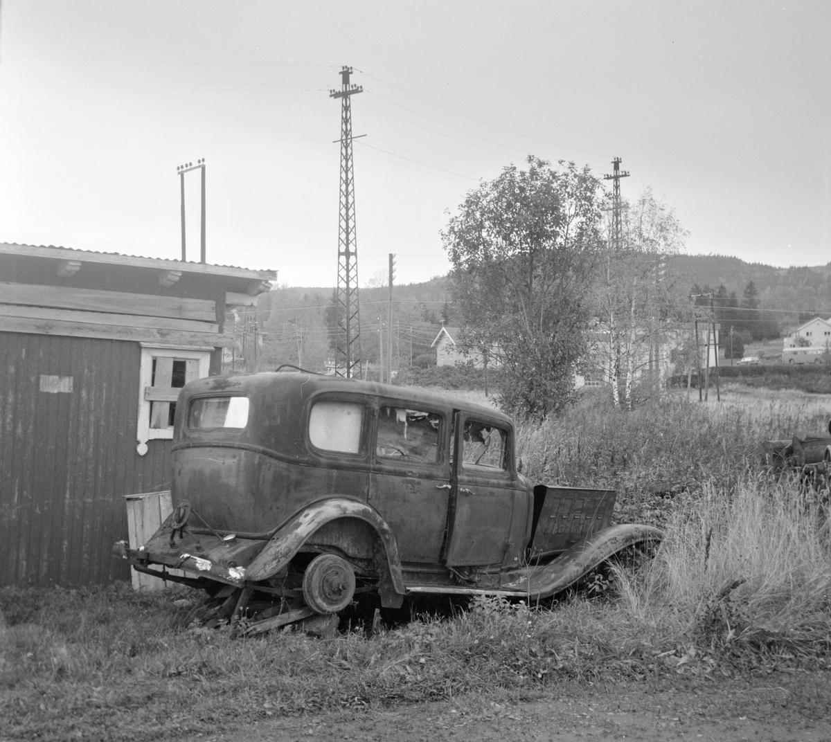 Utedo på Hof stasjon på nedlagte Tønsberg-Eidsfossbanen. I forgrunnen en Buick 1932-modell.