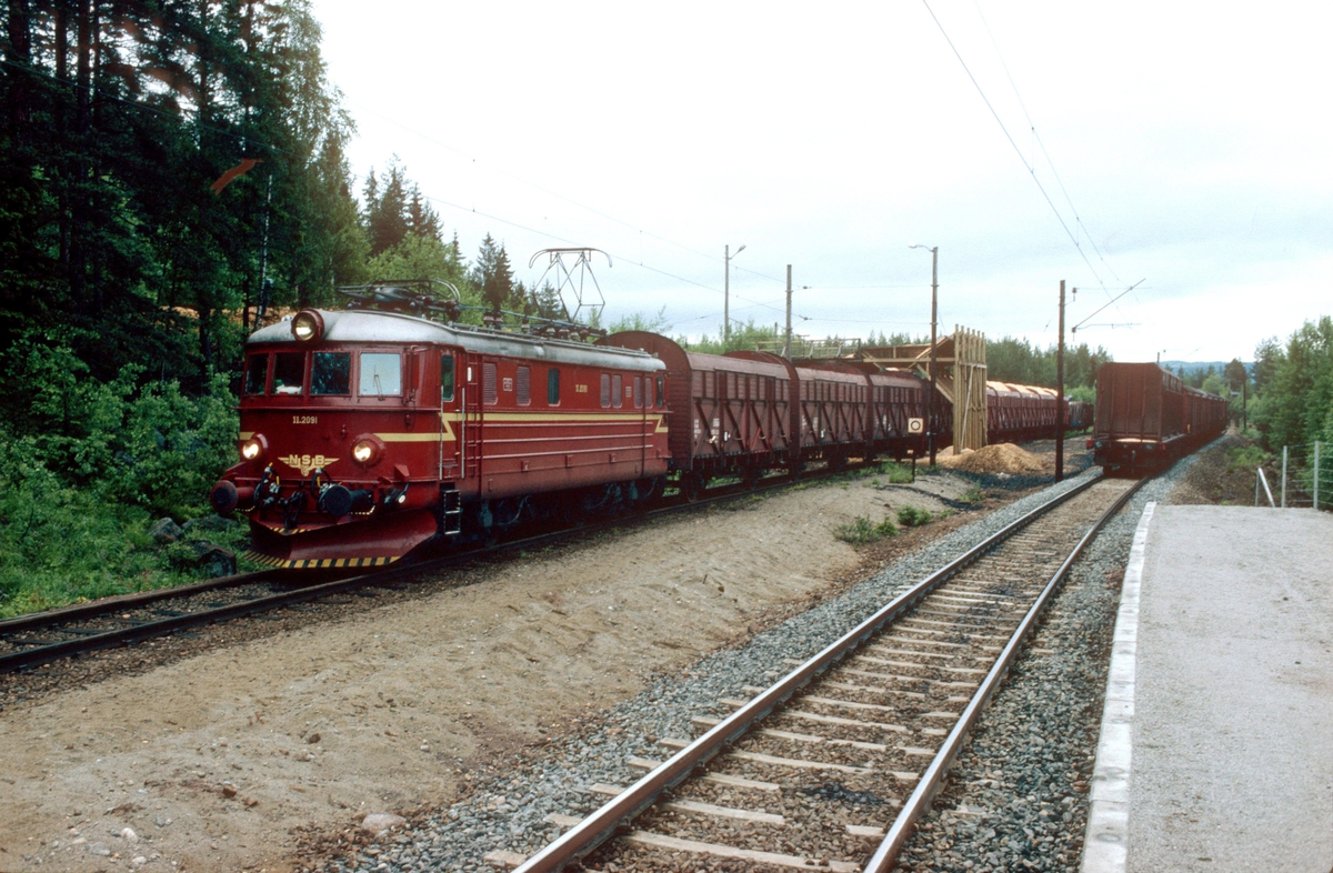 NSB godstog 5165 (Alnabru - Roa) skifter på Lunner almenning sidespor, "Pipern", ved Furumo (Harestua). Elektrisk lokomotiv El 11 2094. Her ble det lastet flis i flisvogner.