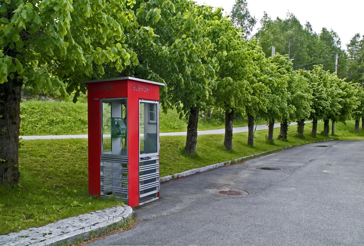 This is the story of how Norway’s most important conversation-space was designed by a young, freshly graduated man from Bergen.

“Norwegian architects are hereby invited…”
In the autumn of 1932, Oslo Telefonanlegginitiated an architectural competition. Finally, Oslo would get its own telephone booth. The city had had so called “talking-stations” from 1885, which in turn were overtaken by automatic telephones 
 only available at selected Narvesen kiosks. The state 
was of the opinion that now was the time to offer the public a better service; public telephone booths open 24/7, like the ones they already had in Sweden and England. But what would they look like, these new telephone booths? What considerations would it
 be necessary to take when designing it? The telegraph board developed a detailed list of demands and restraints: “The booth is intended to be placed outside on the streets and squares and need to be designed so that snow and ice does not hinder the opening and closing of the doors,” they wrote. “To prevent vandalism, theft, uncleanliness etc. inside the booth, it needs to be designed so that from all angles one may see what is going on in there.” Additionally, it would need to withstand storms and bad weather, and “preferably also being whipped by rain mixed with seawater” 

This was not all: The appearance would have to be «pleasing». The booth also needed to be movable, so that it could be taken in to be serviced at Telegrafverket’s main workshops. The reqired material was iron, and the surface was to be spray painted  preferably using car-body paint. There was a requirement for “a writing shelf, a pack shelf, and a suitable place for the telephone catalogue.” Also, there would need to be an illuminated TELEFON  sign, easily visible from all four angles. The total cost for each booth should not exceed 1000 kroner. The first prize for coming up with such a product was 800 kroner.

“Norwegianarchitects are hereby invited to partake in a competition for the design of a telephone booth…”  

The man with the solution
«At some point in 1932, Georg Fredrik sat at a party in Bergen. Maybe he felt a bit lost and forgotten as he often had throughout his life. He retreated to a quiet corner, took out a pencil and strted doodling on a matchbox.  According to my mother, this was how the telephone booth came into being.” In the book “Norges lille røde  historien om telefonkiosken,” Lars Fasting describes his father, the man who is far less known than the iconic architctural structure he left behind. Georg Fredrik Fasting was from Bergen, born into a family of working people and smallholders. One unusual facet of Georg Fredrik was that he was born without ears. His mother made sure he learnt to speak, read and write, 
ut Lars Fasting indicates that his father would seek refuge in drawing when the social challenges became too much to bear. And in the end drawing became his profession. In 1924 he secured a guarantor for a student loan, and started studying to become an a
rchitect at the NTH. Throughout the 1930s he entered several architectural competitions, with drafts produced, according to his son, “after work and in the late hours of the night.”

His efforts were not wasted. Out of 93 entries, with names such as “Flirt”, “Brrr”, “Ring” and “Amor”, the jury selected Fasting’s submission, “RIKS” as the new telephone booth: “The draft shows a strikingly simple solution to the task, technically as well as aesthetically well worked out.”

Taut and provident
Simple and aesthetc are the keywords here. Fasting had designed a booth pointing towards the future, and to modernism. Just how modern it was can be seen by comparing RIKS to the British telephone booth, also designed in the interwar-era. While the British version with it classicistic style is looking back to the heyday of the empire, Fasting’s booth is progressive and functionalistic. Like most Norwegian architects, Fasting broke with the classicistic style of architecture after the Stockholm-exhibition in 1930. “After it, almost all buildings erected in Norway until the German invasion in 1940, were in the functionalistic architectural style,” writes senior curator of architecture at the Norwegian National Museum, Ulf Grønvold, in the book, “Den lille røde”.“TheNorwegian booth is a piece of functionalistic architecture, an asymmetric composition with its roof slab overhanging the word TELEFON, in bold sans seraph lettering,”concludes Ulf Grønvold.

Fashionably red
And it was red. Fasting chose a colour which was part of the modern palette. “A bright red colour, but not as shiny as a signal red, the character of the colour places it among the fashionable colours within functionalism,” states paintings conservator and researcher in NIKU (Norwegian Institute for Cultural Heitage Research), Jon Brænne. In his opinion, Fasting went for visibility without making the booth stand out too much from its surroundings. The original colour was in use up to around 1950, when it changed to signal red. Towards the end of the 1970s the clour was again adjusted towards today’s orangey red.

The design, however, has not changed. RIKS is eighty years and still looks remarkably good. That’s what makes Fasting’s telephone booth a classic  even before it was added to DOCOMOMO’s list over moden icons of design. For Telenor, the telephone booth has served as a pathway into the hearts of the public. For many, Telenor (Televerket) was synonymous with exactly this telephone booth, because this was where one would go to place a call. Having a home
phone was not common until the 1980s. As such the red box became part of the Norwegian everyday and consciousness. The symbol- and publicity value of this is hard to evaluate, but in 2007 it was time to give honour where honour was due, Telenor, in consul
tation with the Directorate for Cultural Heritage, decided to preserve 100 telephone booths for all eternity.

And what about Georg Fredrik Fasting? What happened to him? At the age of 56 an entry in his diary states: «I CAN HEAR». As the first person in th world he had undergone an operation where he had ear canals constructed and eardrums fitted. For the rest of his life, the man behind Norway’s own telephone booth could answer the telephone himself.

Source: Norges lille røde historien om telefonkiosken (2007), issued by The Norwegian Telecom Museum and Telenor Cultural Heritage.