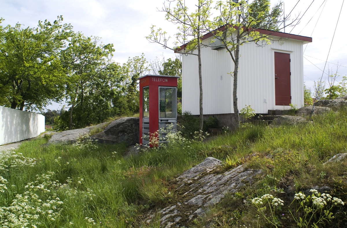 Denne telefonkiosken, som står i Ytre Lyngør, er en av de 100 vernede telefonkioskene i Norge. De røde telefonkioskene ble laget av hovedverkstedet til Telenor (Telegrafverket, Televerket). Målene er så å si uforandret. 
Vi har dessverre ikke hatt kapasitet til å gjøre grundige mål av hver enkelt kiosk som er vernet. 
Blant annet er vekten og høyden på døra endret fra tegningene til hovedverkstedet fra 1933.
Målene fra 1933 var:
Høyde 2500 mm + sokkel på ca 70 mm
Grunnflate 1000x1000 mm.
Vekt 850 kg.
Mange av oss har minner knyttet til den lille røde bygningen. Historien om telefonkiosken er på mange måter historien om oss.  Derfor ble 100 av de røde telefonkioskene rundt om i landet vernet i 1997. Dette er en av dem.