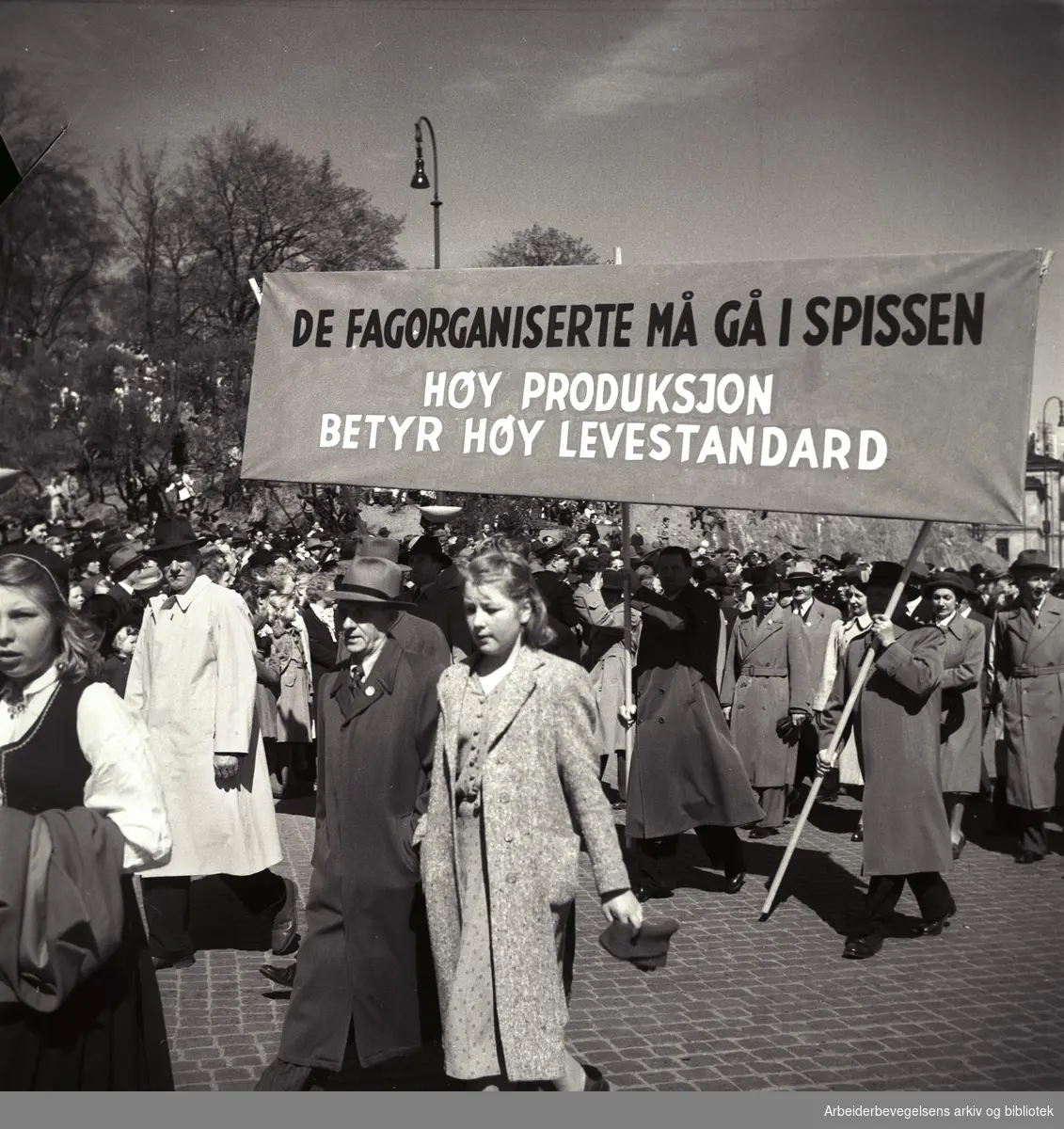 1. mai 1950, demonstrasjonstoget. Parole: Vi fagorganiserte må gå i spissen. Høy produksjon betyr høy levestandard.