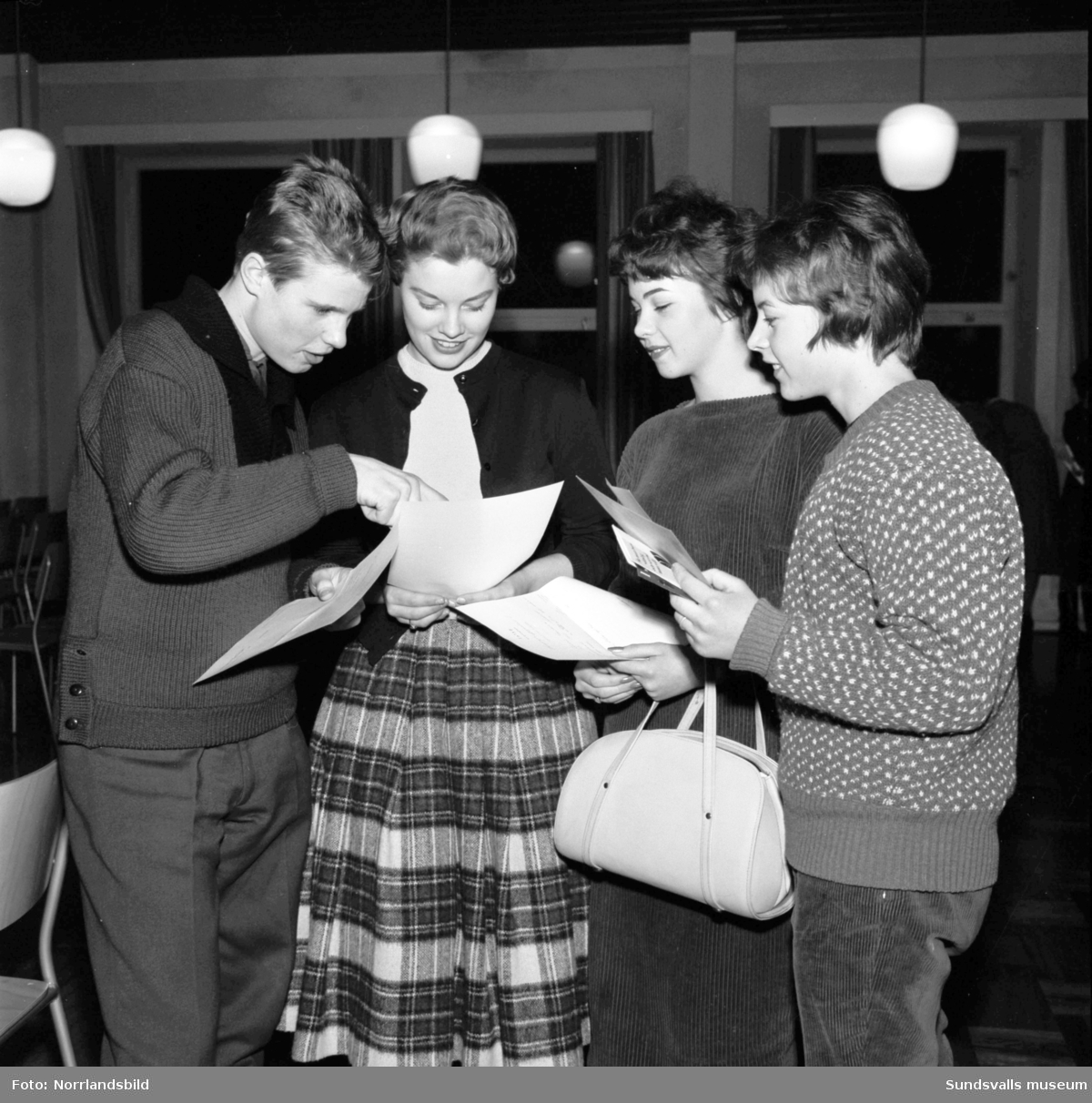 Examen vid Handelsskolan  i Sundsvall 1959. Fyra studenter vid maskin- och stenografkursen jämför sina betyg.
