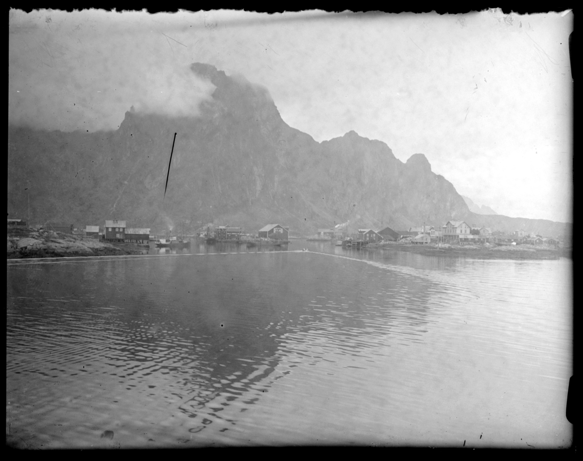 Svolvær sett fra sjøsiden, med Svinøya til høyre i bildet. Bildet er trolig tatt fra Hurtigruta. En liten båt er på vei mot havna. Se også FBib 93149-005