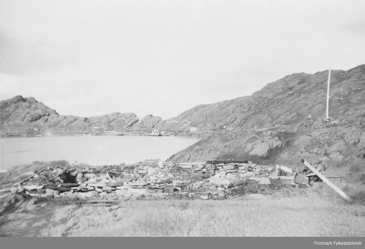 Oversiktsbilde fra Tufjord (i Måsøy kommune). I forgrunnen kan vi se ruiner, antakelig av en gammel bolig. I bakgrunn ser vi en holme som strekker seg utover. 
