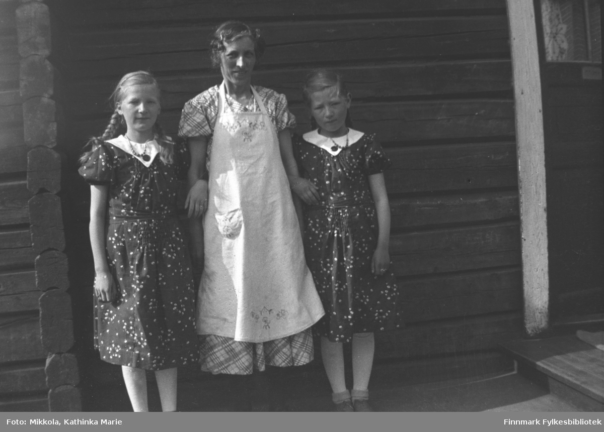 Valborg Nilsen arm i arm med jentene Gudrun (til venstre) og Kari Mikkola. Jentene har fine kjoler og kan være 9-12 år gamle. Bildet er tatt i Kirkenes
