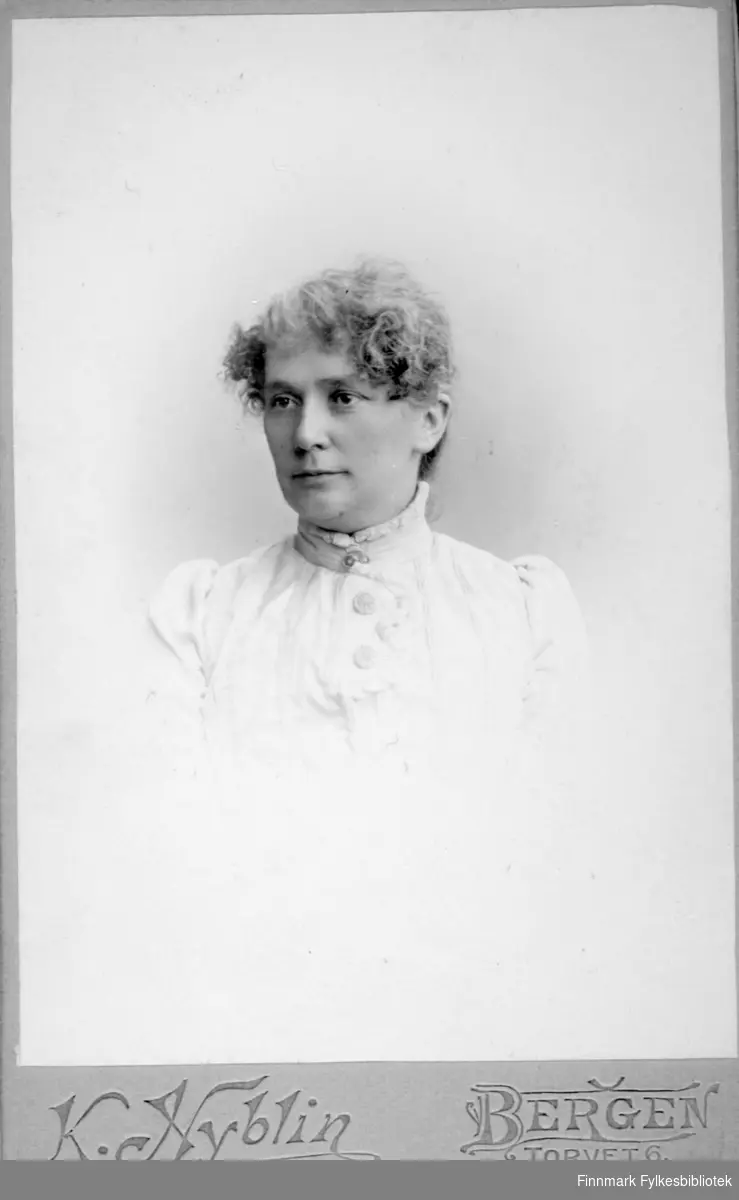Portrett av en dame i en hvit bluse. Portrettet er tatt hos K. Nyblin atelier i Bergen.