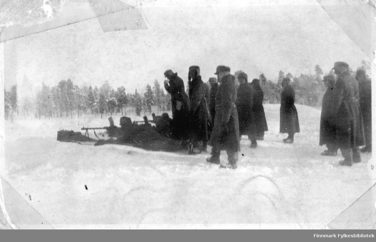 Soldater skyter og har øvelse i snøen, flere soldater står rundt, muligens av høyere rang. Grensevakt, garnisonen i Sør-Varanger