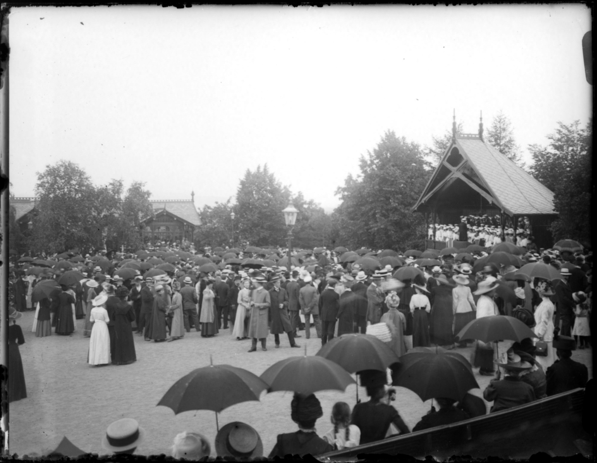Fra stevne 1912. Se også bilder FBib.83002- 373-391. folkemengde på et torg. Flere har paraplyer, så det regner nok.